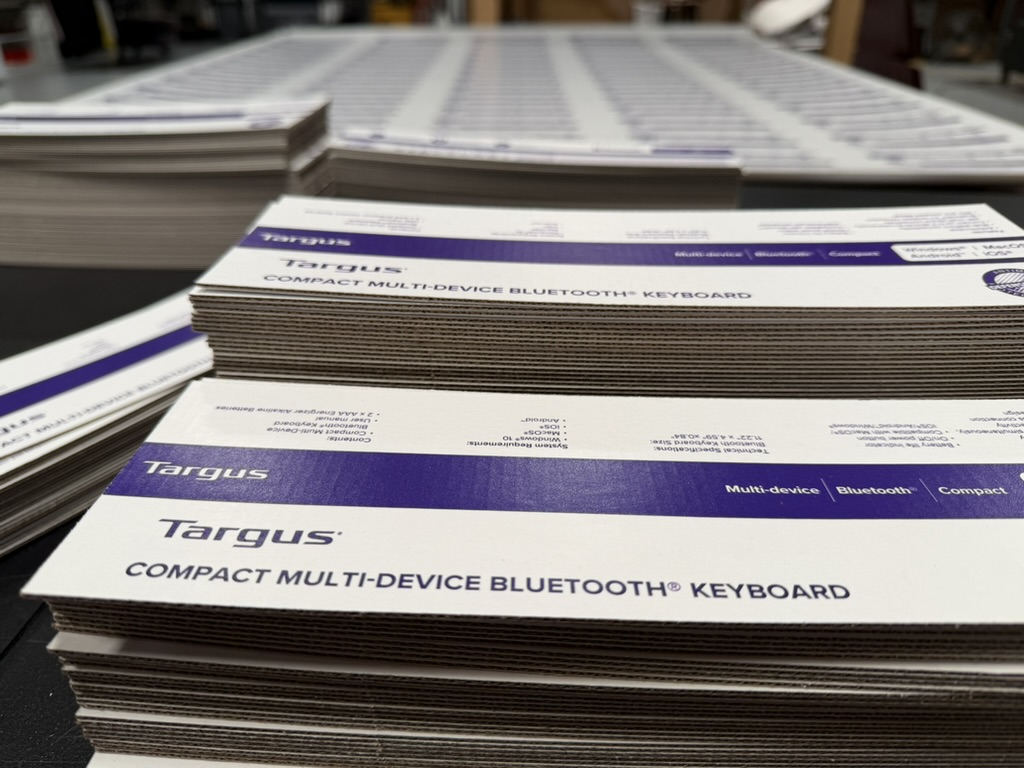 Stacks of identical die-cut Targus retail cartons fresh off the press — documented spec, no variance